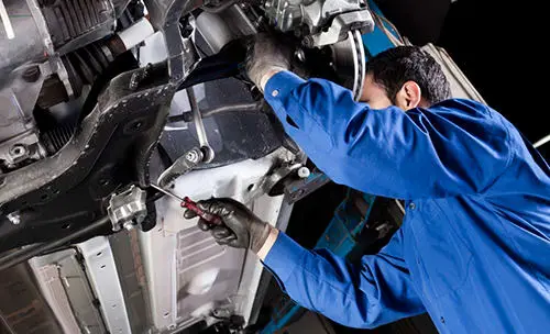 Technician working under a raised vehicle