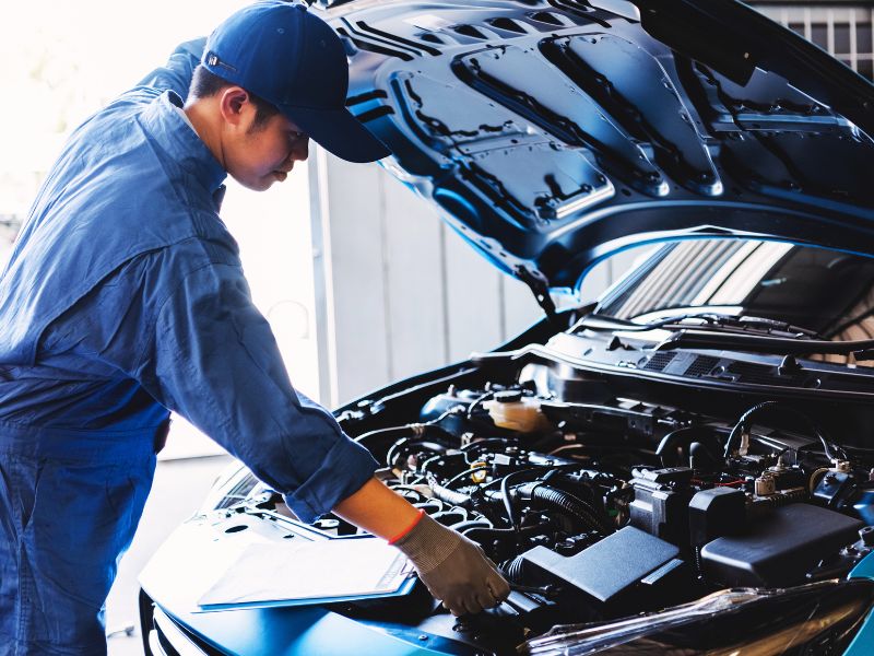 Technician inspecting an open engine bay